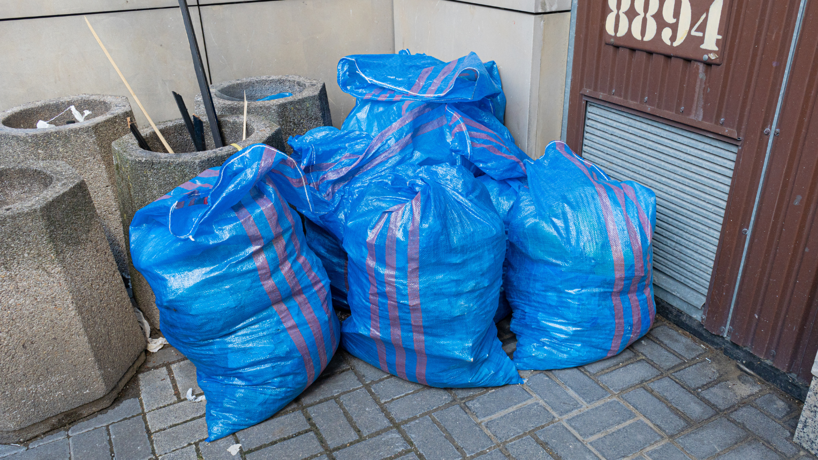 A pile of blue bags sitting on the side of a building