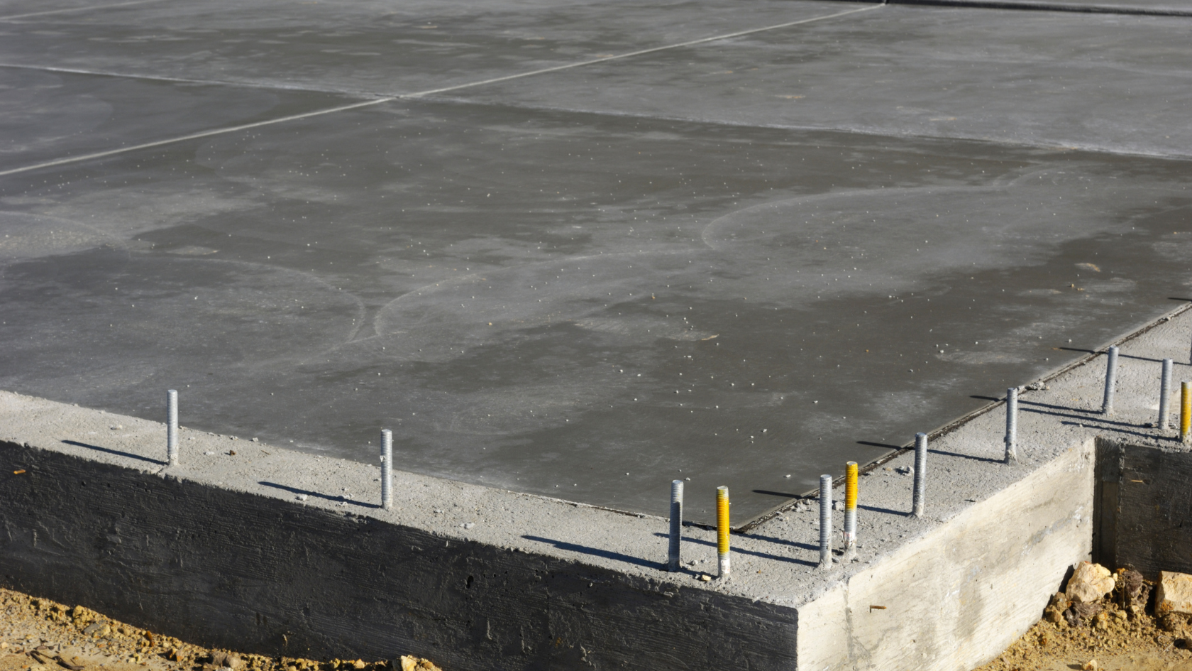 A concrete slab is being constructed into a tennis court