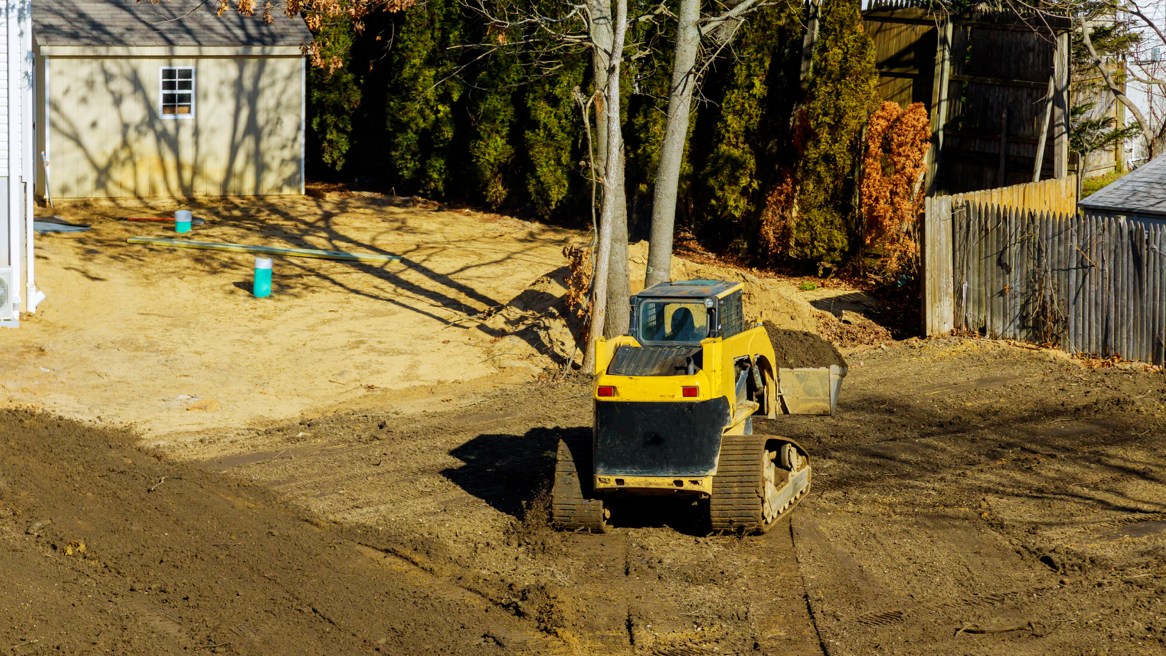 A yellow bulldozer is parked in the dirt